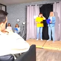 two people standing on stage with a laptop