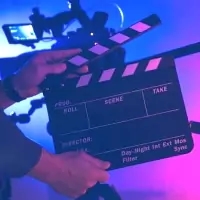 a person holding a clap board in front of a camera