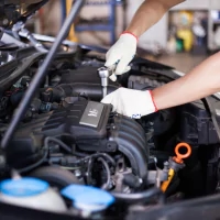 a man working on a car engine in a garage