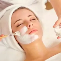 a woman getting a facial mask at a beauty salon
