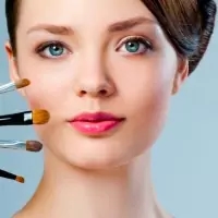the face of a woman with makeup brushes