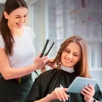 a woman getting her hair styled by a hair stylist