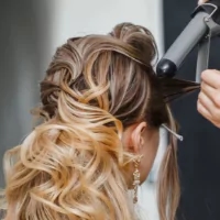 a woman getting her hair styled by a hair stylist