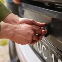 the number plate of a black oven with a person's hand
