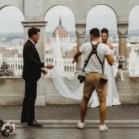a man with a camera and a woman in a white dress