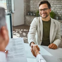a man in a suit and glasses sitting at a table