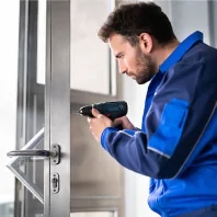 a man using a cordless driller to fix a window