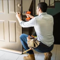 a picture of a man using a cordless drill to fix a door