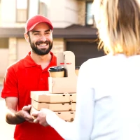 a man in a red shirt and a red cap holding a cell phone