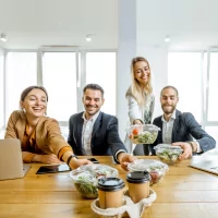 a group of people sitting around a table with a laptop