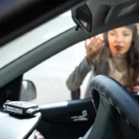 a woman in a car with a cell phone in her hand