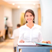 a woman is sitting at a desk with a book