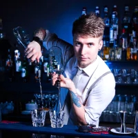 a man is making a drink at a bar