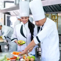 a group of chefs preparing food in a kitchen