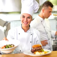 a woman in a chef's hat holding a plate of food