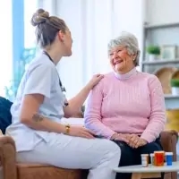 a woman sitting on a couch with a nurse