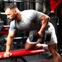 a man doing a dumbble weight exercise in a gym