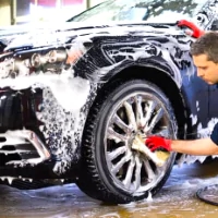 a man washing a car with a sponge