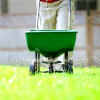 a lawn spreader being used to spread grass