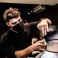 a man getting his hair cut by a barber
