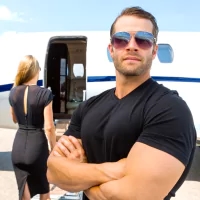 a man in sunglasses standing in front of a plane