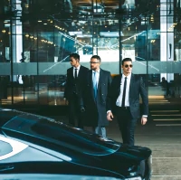 the image is a man in a suit and tie walking with two other men