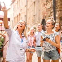 a woman in a white shirt and blue lanyard holding a cell phone