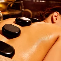 the back of a woman getting a hot stone massage