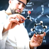 a hand holding a model of a molecule