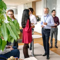 a group of people standing around a table with drinks