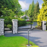 a driveway with a gate and a driveway with a bike rack