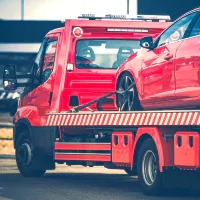 a red car being towed by a tow truck