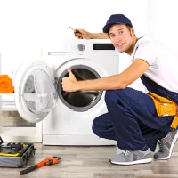 a man kneeling down to pick up a washing machine