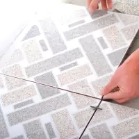 a person cutting a piece of paper with a knife