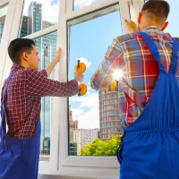 two men in overalls cleaning windows with oranges