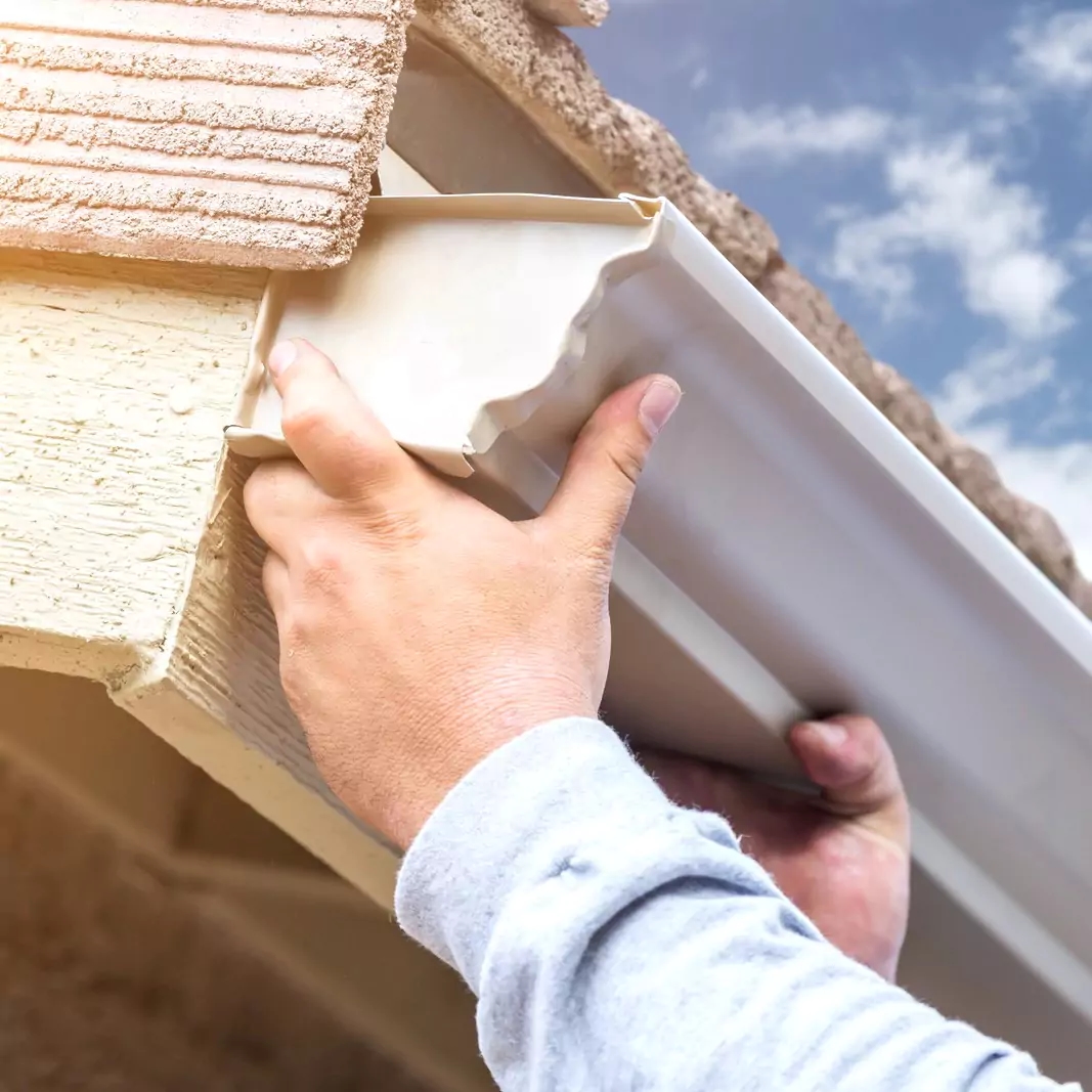 a person holding a piece of wood with a sky background
