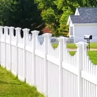 a white picket fence with a mailbox in the background