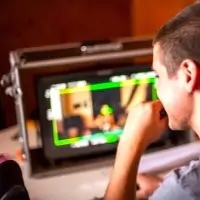 a man sitting in front of a tv playing watching a movie
