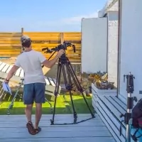 a man holding a camera and a tripod