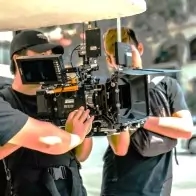a man with a camera and a woman with a hat