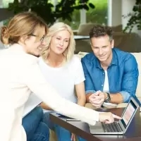 a group of people looking at a laptop computer